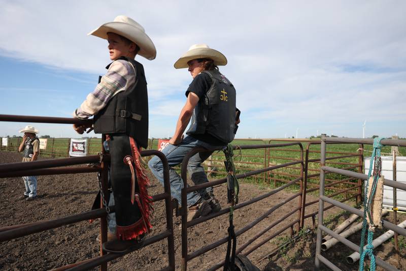 Dominic Dubberstine-Ellerbrock, right, sits with Wyatt Plese watching a fellow bull rider takes his turn during practice. Dominic will be competing in the 2022 National High School Finals Rodeo Bull Riding event on July 17th through the 23rd in Wyoming. Thursday, June 30, 2022 in Grand Ridge.