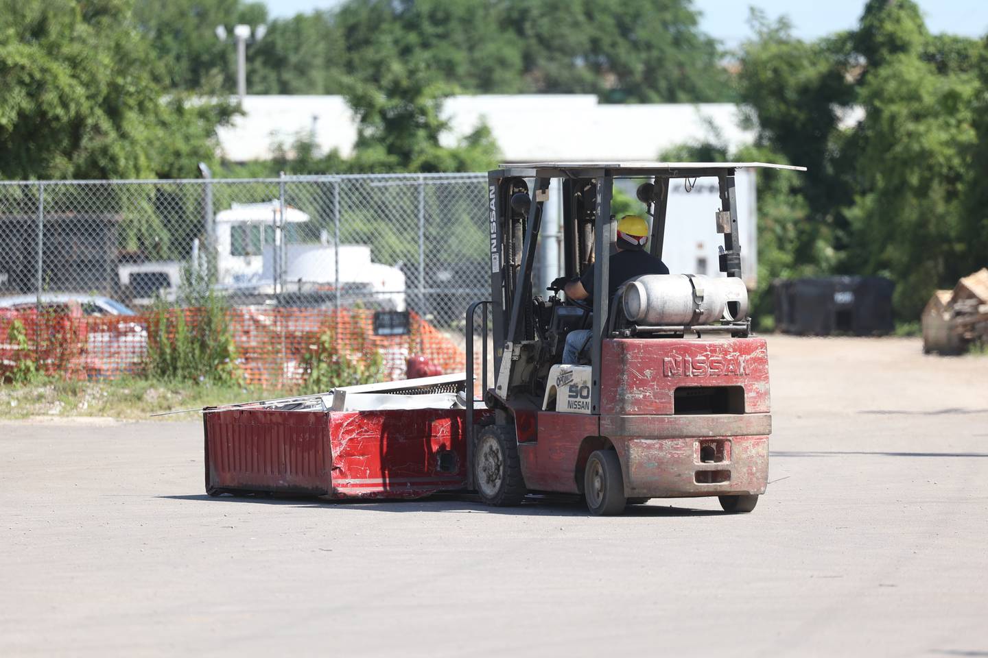 A worker moves a pile of scrap at Berlinsky Scrap. Friday, July 22, 2022 in Joliet.