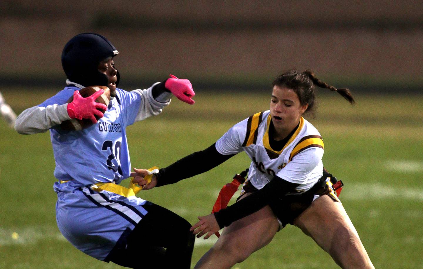 Jacobs’ Ava Nisi, right, grabs the flag of Rockford Guilford’s Mya Page in varsity flag football sectional action at Dan Horne Field on the campus of Harvard High School in Harvard  on Tuesday, Oct. 15, 2024.