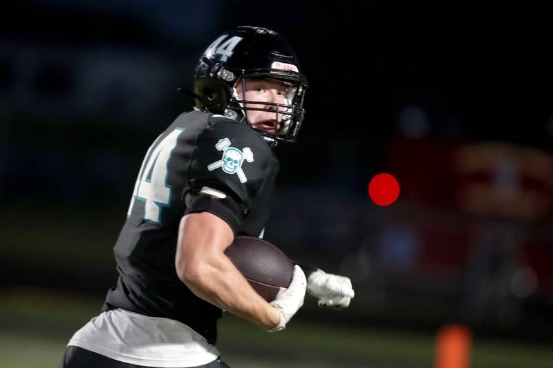 Woodstock North’s Brady Rogers peeks back before landing in the end zone with a touchdown in varsity football at Rod Poppe Field on the campus of Marengo High School in Marengo on Friday, Sept. 12, 2025.
