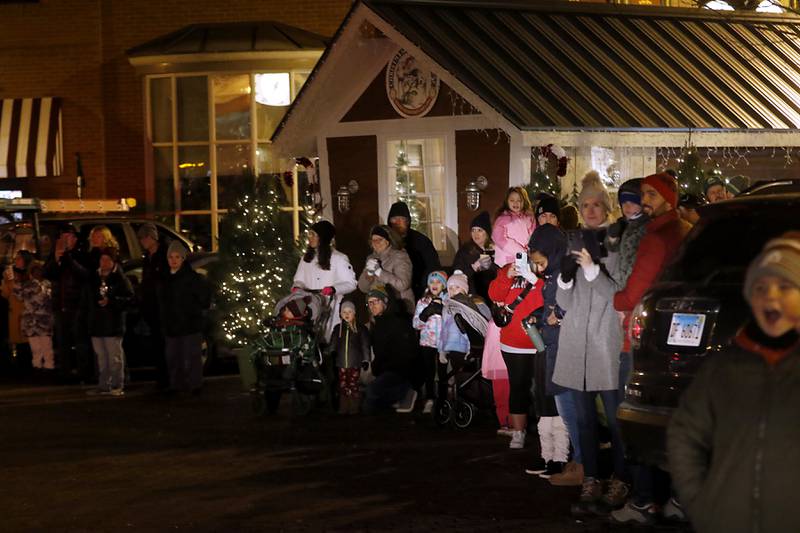 People wait for the arrival of Santa Claus during the Lighting of the Square Friday, Nov. 24, 2023, in Woodstock. The annual holiday season event featured brass music, caroling, free doughnuts and cider, food trucks, festive selfie stations and shopping.