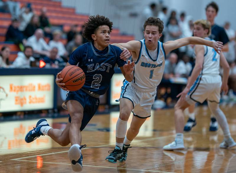 Oswego East's Bryce Shoto (2) drives the baseline against Downers Grove South's Freddie Kuhlman (1) during the hoops for healing basketball tournament at Naperville North High School on Monday, Nov 21, 2022.