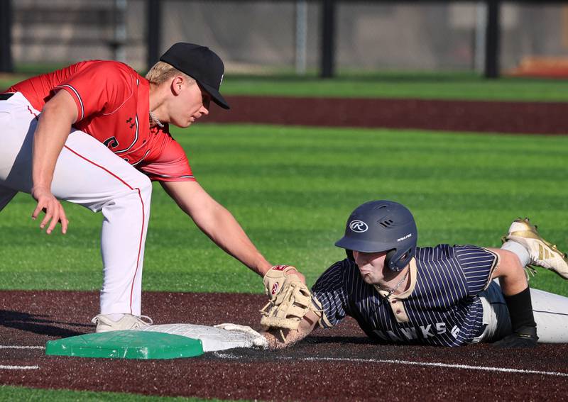 Hiawatha's Aidan Cooper dives safely back to first as South Beloit's Richard Carlson applies the tag Thursday, April 16, 2026, during their game at Northern Illinois University in DeKalb.