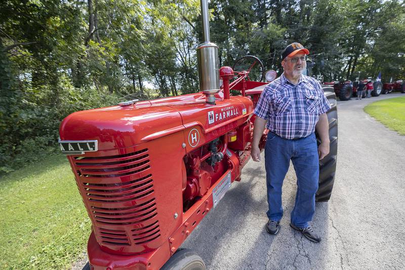 Parade leader Ivan Shank stands with his father’s first tractor, a restored 1945 Farmall, Saturday, Aug. 31, 2024, at Lowell Park in Dixon.