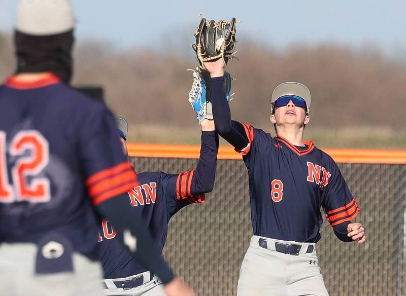 Naperville North's Caden Vorwick makes a catch despite colliding with teammate Sam Steele Tuesday, April 15, 2025, during their game at DeKalb High School.