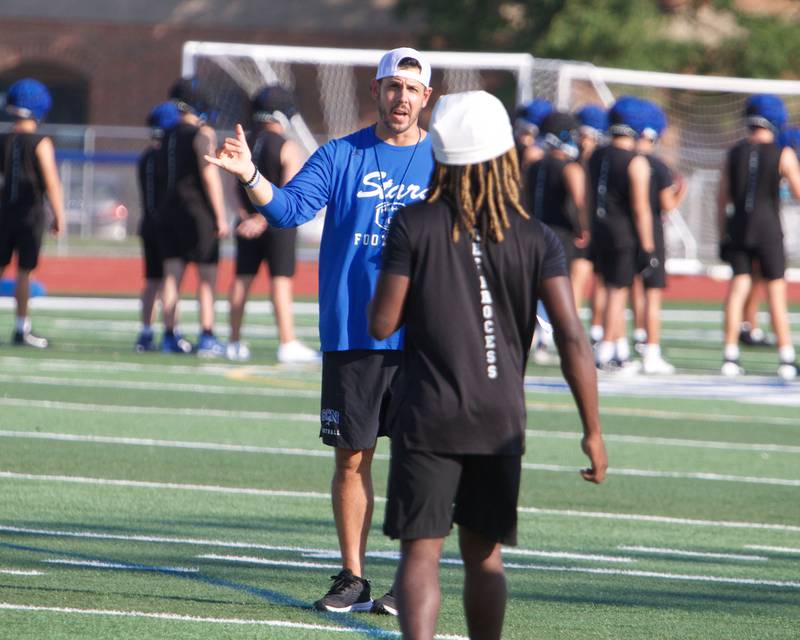 St. Charles North Varsity Coach Rob Pomazak talks with a player at their first practice on Monday, Aug.11,2025 in St. Charles.