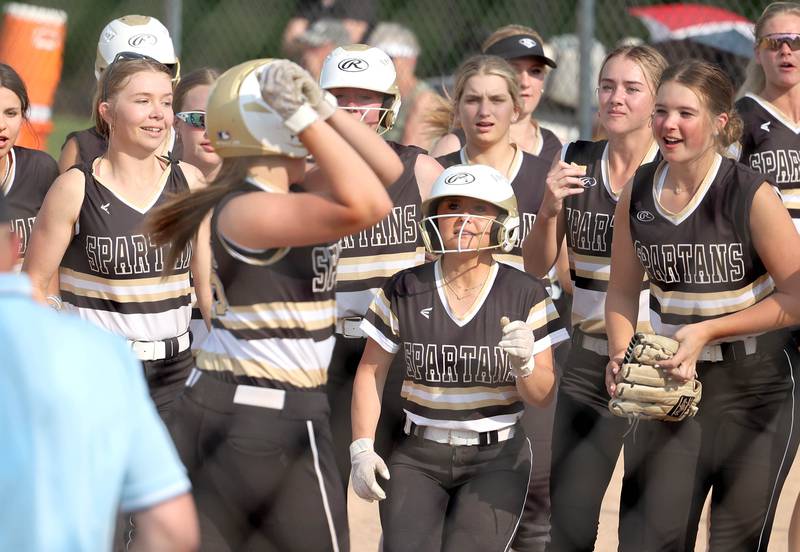 Sycamore's Kaitlyn Williams is greeted by teammates at home after her second inning grand slam during their IHSA Class 3A regional contest against Dixon Tuesday, May 23, 2023, at Sycamore High School.