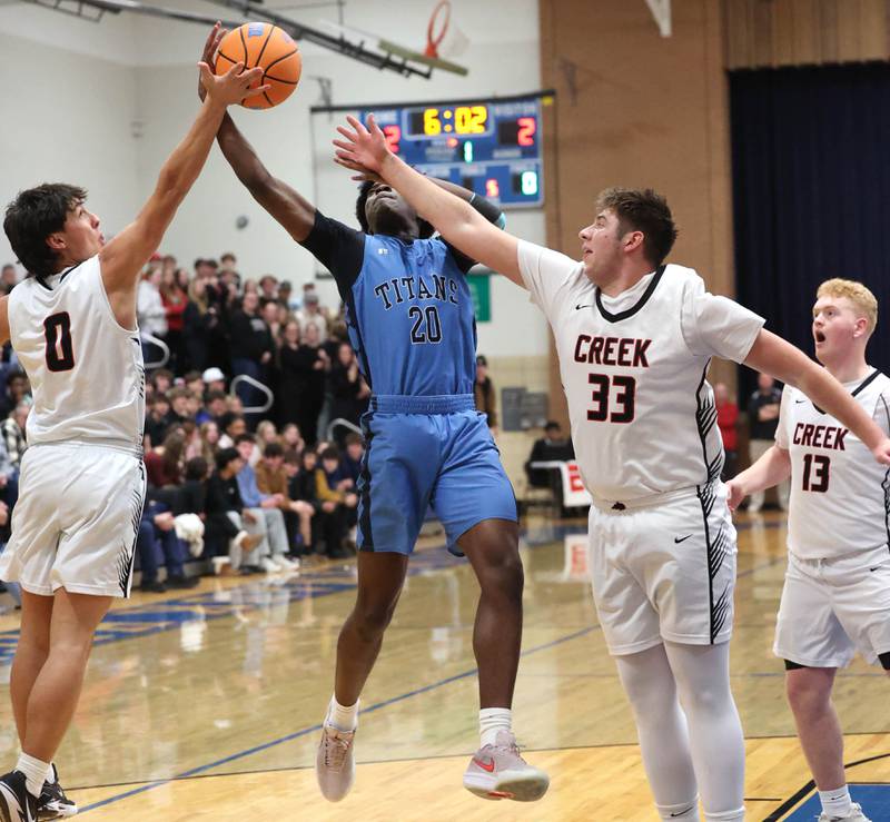 IMSA’s Mofe Suleiman grabs a rebound between Indian Creek's Cooper Rissman (left) and Payton Hueber Friday, Feb. 6, 2026, during their Little 10 Conference championship game at Somonauk High School.