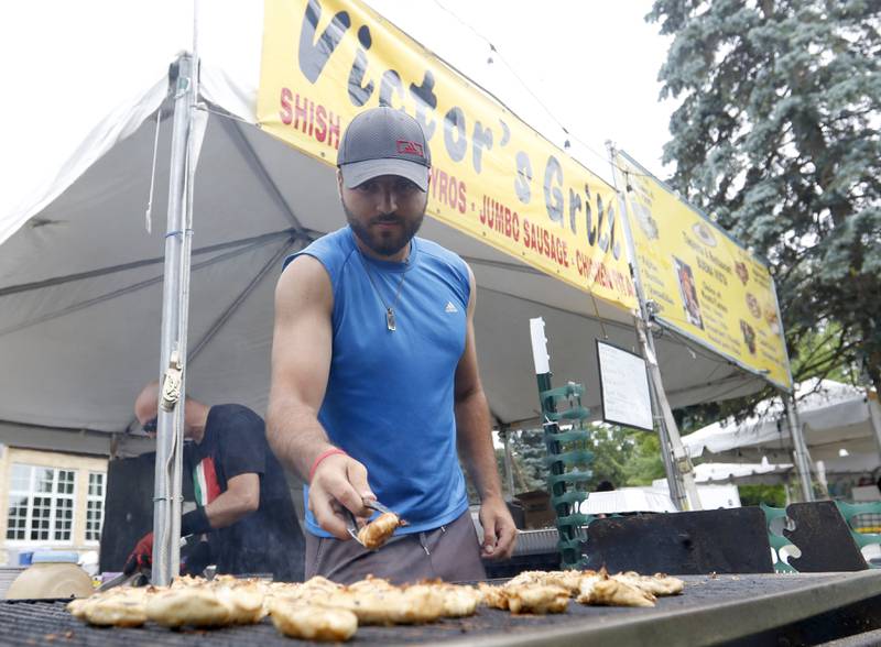 Marc Karman of Victors’s Grill cooks chicken Friday, July 1, 2022, during Lakeside Festival at the Dole and Lakeside Arts Park, 401 Country Club Road in Crystal Lake. The festival continues noon to 11 p.m. July 2 and noon to 10 p.m. July 3. The festival features bands on two outdoor stages, food and drinks, a baggo tournament, and carnival rides and games. Among the activities for kids are face painting, a balloon twister, a stilt walker, team mascots and a magician.