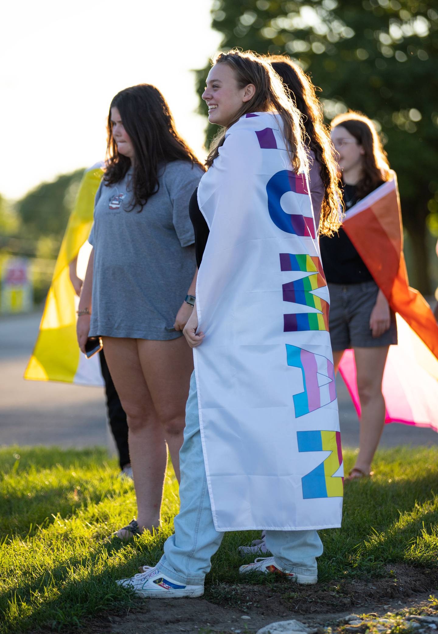 Jessica Swanson, 17, of Geneva wears a flag that says the word "human" during the Pride Fire Hydrant Rally at the northwest corner of Kirk Road and State Street/Rte. 38 in Geneva on Tuesday, Aug. 9, 2022.