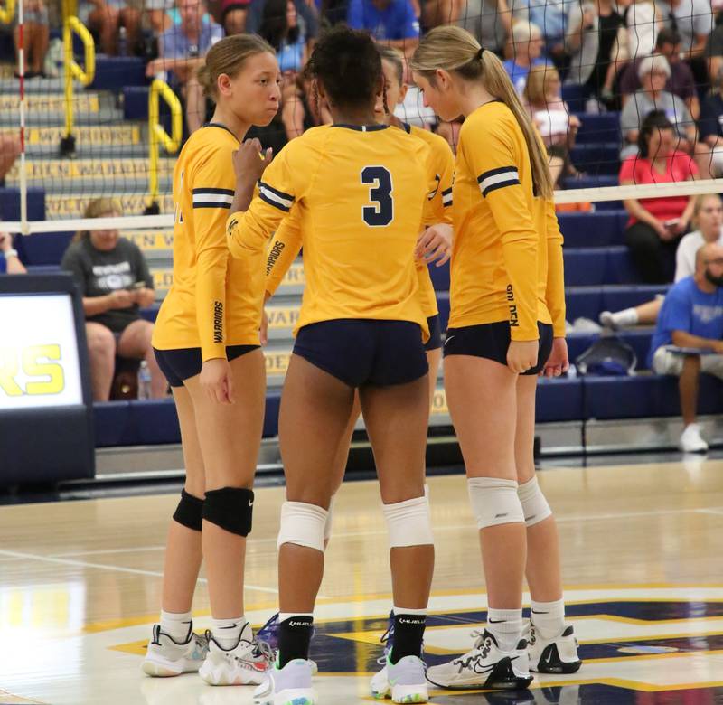 Olivia Melcher (right) huddles up with volleyball teammates Kirra Gibson (left) and Merrick Amanwka after a play.