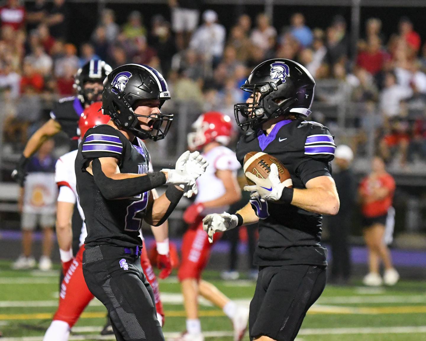 Downers Grove North's Connor Crowley, left, celebrates with teammate Max Troha after Max intercepts the ball from a Hinsdale Central defender during the game on Friday Sept. 12, 2025, held at Downers Grove North High School.