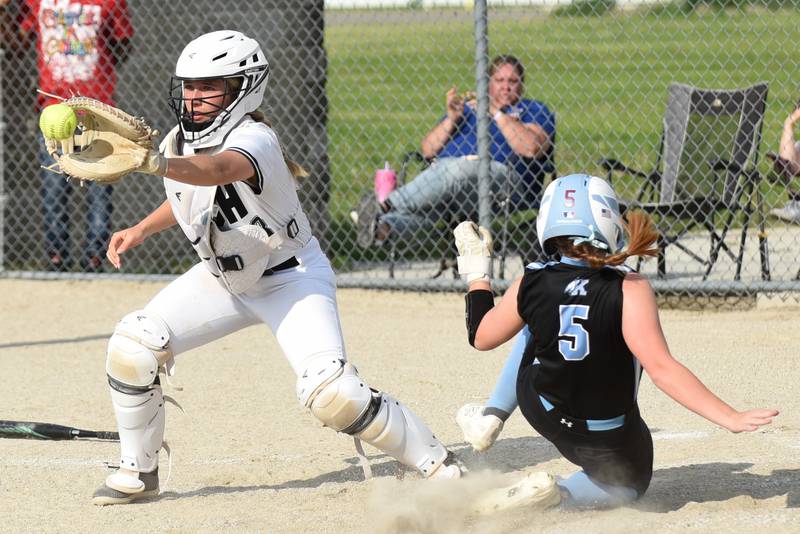 Bishop McNamara's Bridget Bertrand, left, fields a throw at home as Kankakee's Lillian Landis slides in for a run during a game at Bishop McNamara Tuesday, May 13, 2025.