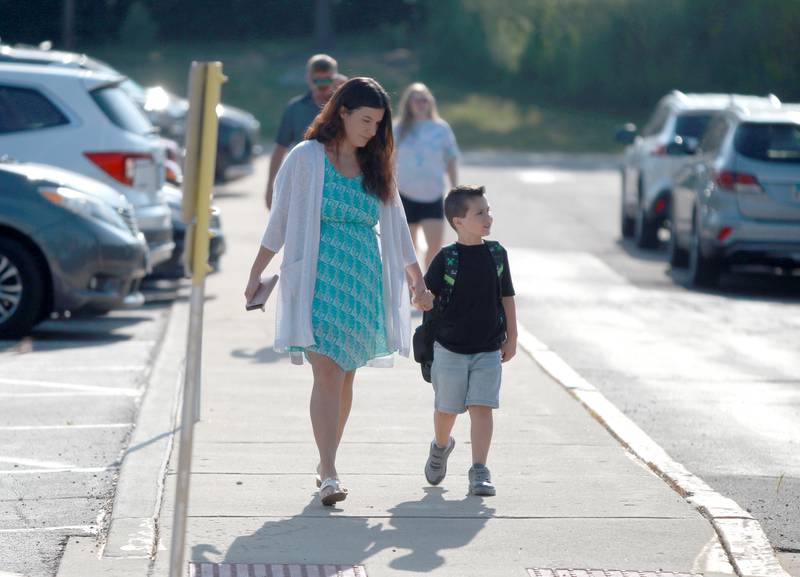 Shelby Williams walks with her son Milo to his first day of second grade at Fox Ridge Elementary School in St. Charles on Wednesday, Aug. 14, 2024.