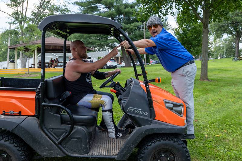 (left to right) Hartenbower drives RTV with WWF Hall of Famer Sidney Bakabella holding onto front cage at the Taste of the Illinois Valley DreamWave Wrestling event on Saturday, August 2, 2025 at Centennial Park in Peru.