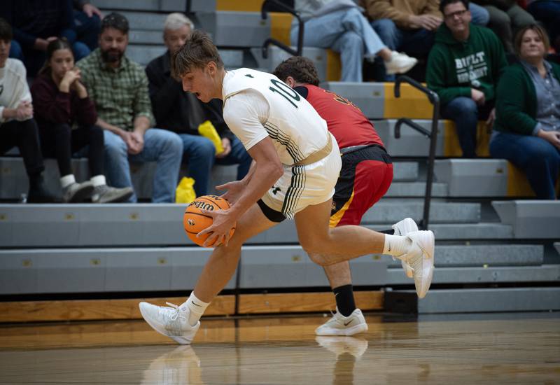 Bishop McNamara's Coen Demack picks up a loose ball over St. Anne's Brandon Schoth, background, in a game on Wednesday, November 26, 2025.