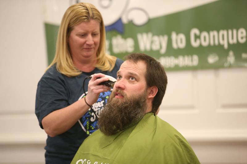 John Hamilton, has his head shaved by beautician Sarah Stewart of Downstairs on 1st Day Spa during the 18th annual Illinois Valley Emergency Services St. Baldrick's event on Sunday, March 23, 2025 at Senicas Oak Ridge in La Salle.
