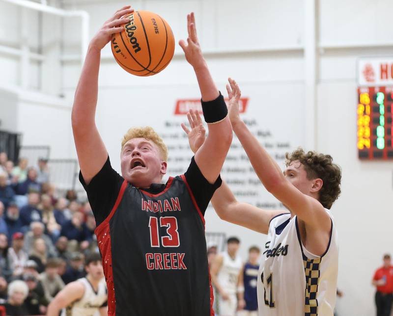 Indian Creek's Isaac Willis grabs a rebound over Marquette's Lucas Craig during the Class 1A Sectional game on Friday, March 6, 2026 at Amboy High School.