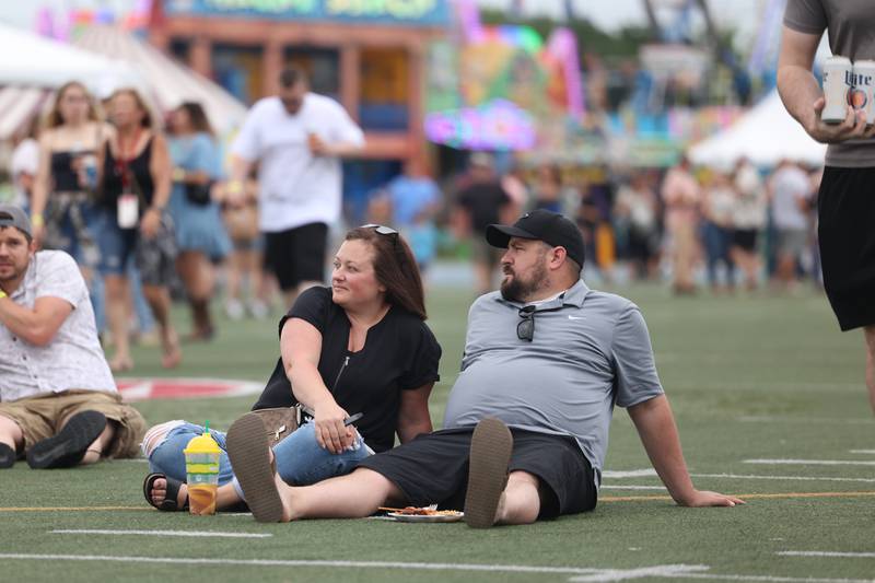 Darius and Gabby Regan, of Coal City, find an open spot on the field to watch Tae Dye of Maddie & Tae perform on day 2 of the Taste of Joliet. Saturday, June 25, 2022 in Joliet.