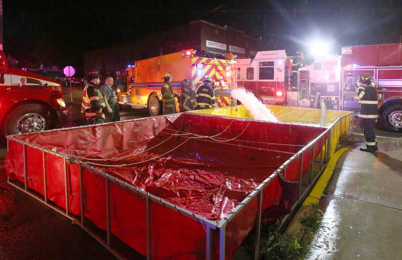 Firefighters fill tender boxes at Walnut and 5th Streets to fight a fire across from the Westclox building on Friday, July 14, 2023 in Peru. The fire began at 8:19p.m. A MABAS box alarm was issued to the fourth level and then brought back down after the fire was contained.