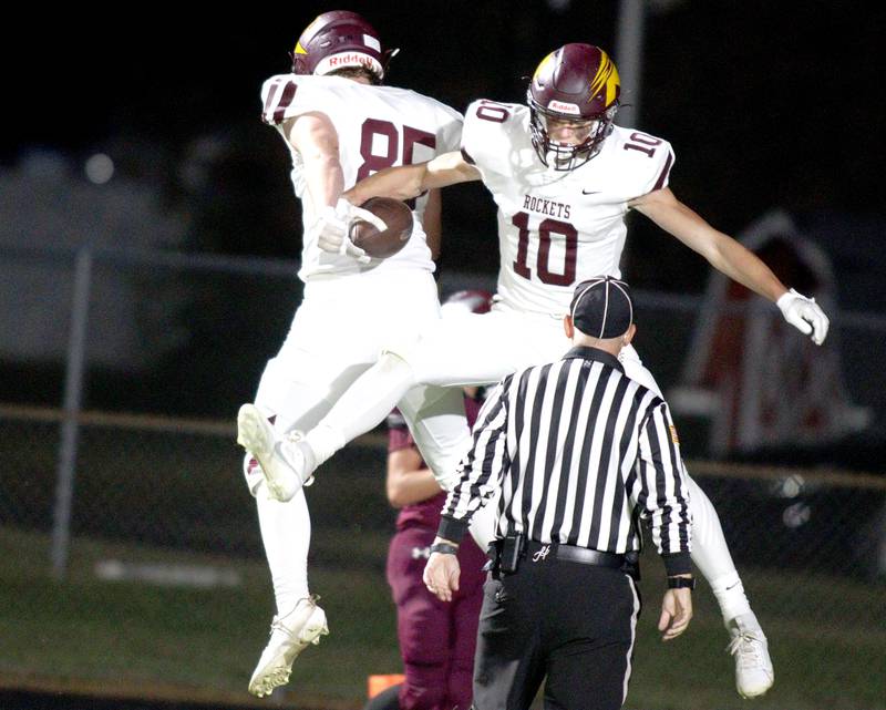 Richmond-Burton’s Max Loveall (10) celebrates with teammate Lukas Bresnahan (85) after a touchdown in varsity football at Rod Poppe Field in Marengo Thursday night.