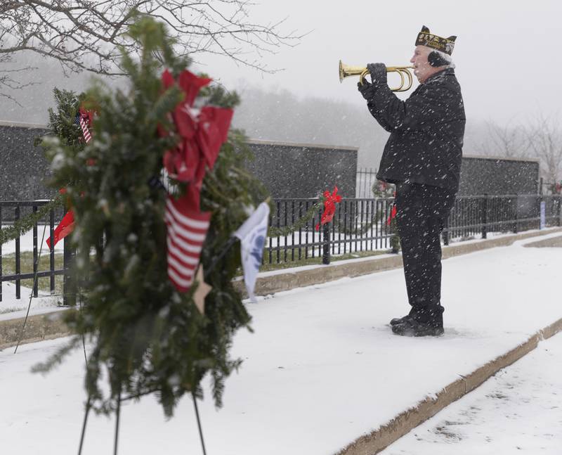Glen Borvansky of Marseilles VFW Post 5506, plays taps concluding the Wreaths Across America ceremony Saturday at the Middle East Conflicts Wall Memorial in Marseilles. Over 100 wreaths were placed along the wall.