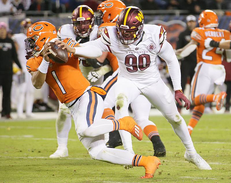 Chicago Bears quarterback Justin Fields runs with the football as he is being chased down by Washington Commanders defensive end Montez Sweat (90) on Thursday, Oct. 13, 2022.