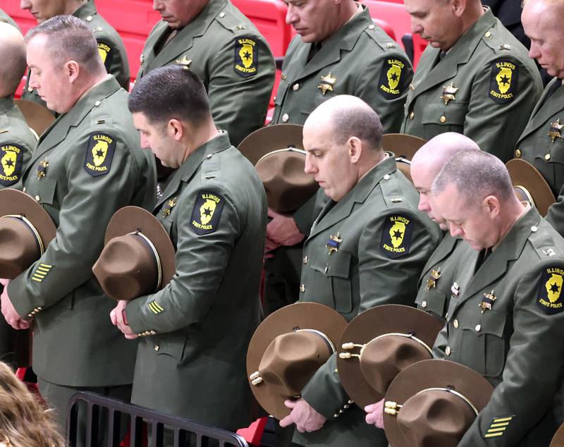 Illinois State Police officers bow their heads Thursday, April 4, 2024, during the visitation and funeral for DeKalb County Sheriff’s Deputy Christina Musil in the Convocation Center at Northern Illinois University. Musil, 35, was killed March 28 while on duty after a truck rear-ended her police vehicle in Waterman.