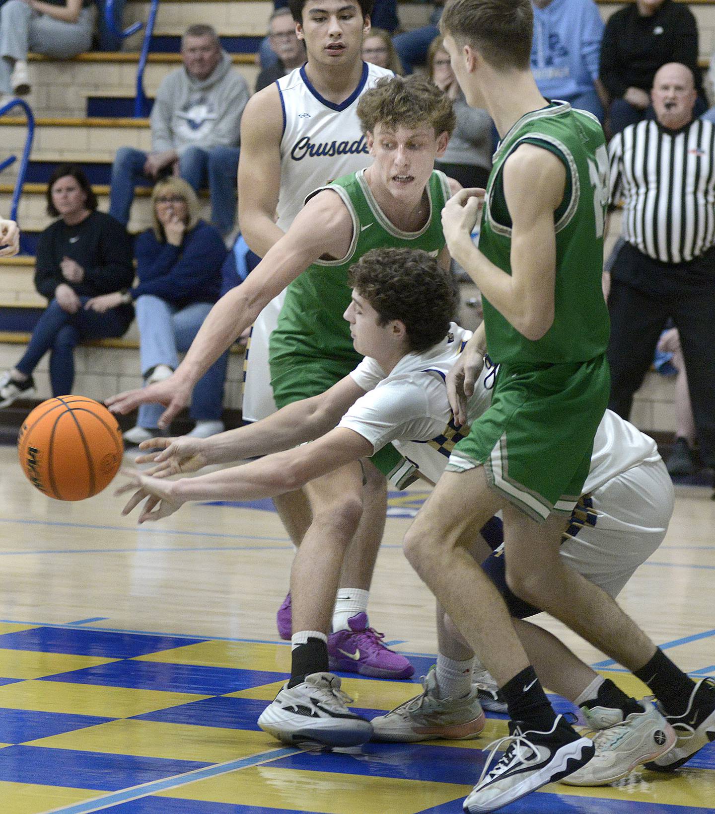 Marquette’s Easton Debernnardi battles for a loose ball with Dwight’s Joey Starks and Trevor Jensen in the 2nd period Monday at Marquette.
