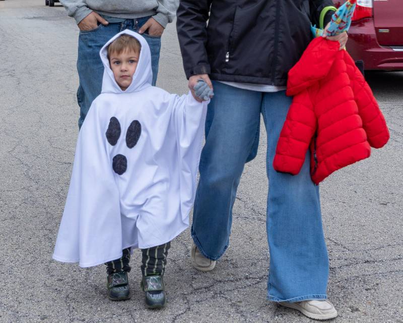 Jonathan Illingwort holds hands of mother, Sam as they walk to the trunk or treat event on Saturday, October 25, 2025 at Illinois Valley Auto Group in Peru.