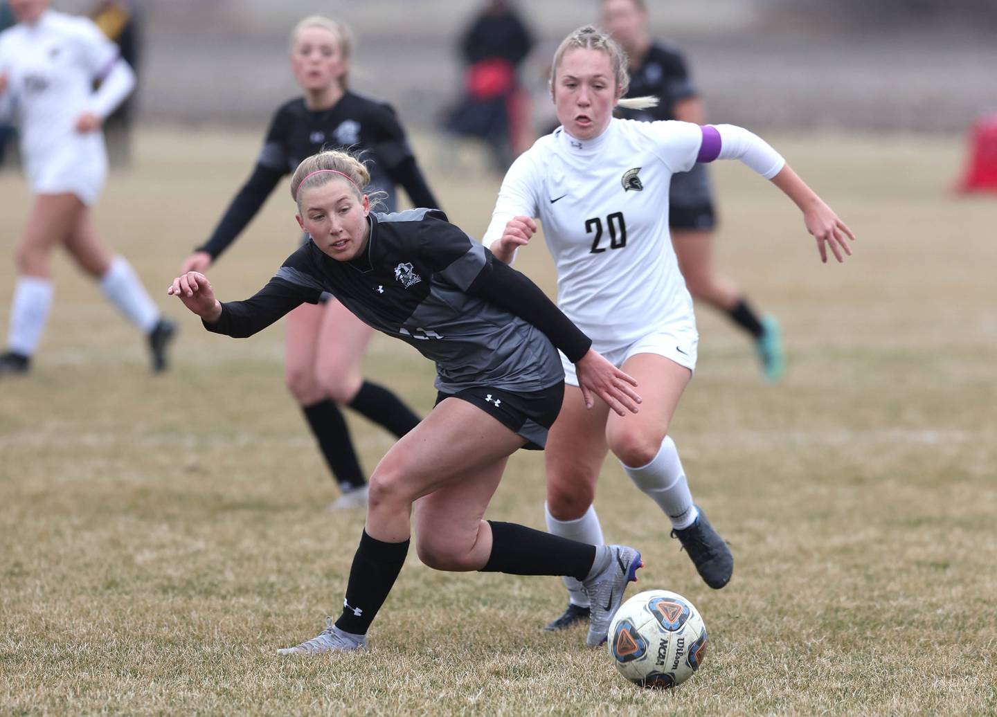 Kaneland's Madie Nitsche and Sycamore's Karli Kruizenga go after a loose ball during their game Monday, April 4, 2022, at Kaneland High School in Maple Park.