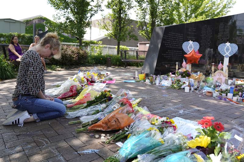 A visitor prays at a memorial to the seven people killed and others injured in Monday's Fourth of July mass shooting at the Highland Park War Memorial in Highland Park, Ill., Thursday, July 7, 2022. (AP Photo/Nam Y. Huh)