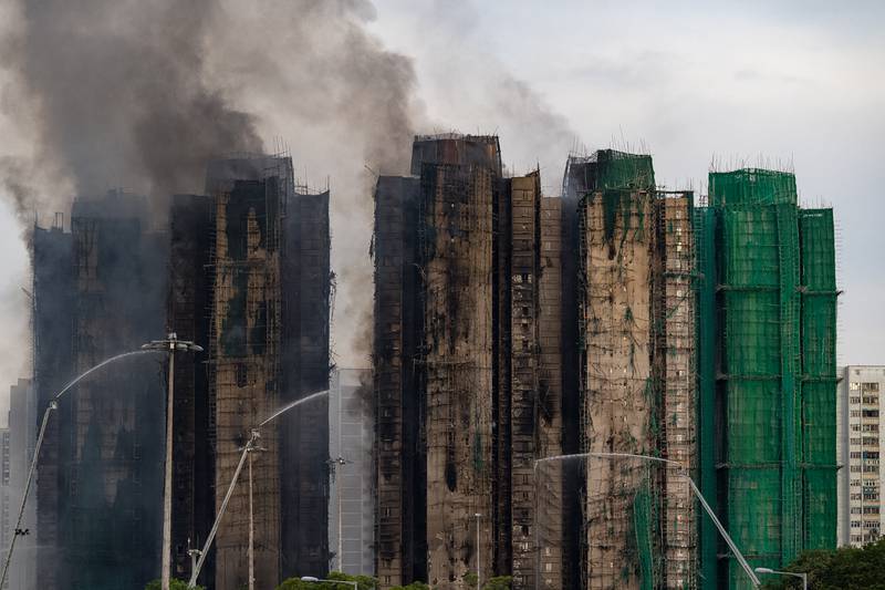 Firefighters work to extinguish a fire which broke out Wednesday at Wang Fuk Court, a residential estate in the Tai Po district of Hong Kong's New Territories, Thursday, Nov. 27, 2025. (AP Photo/Chan Long Hei)