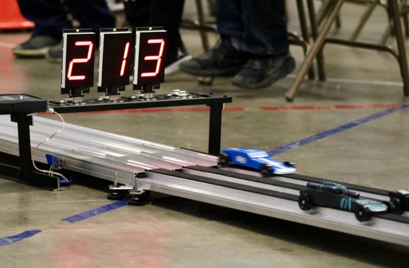 Pinewood derby cars race through the electronic sensors at the end of the finish line on Saturday, Feb. 11, 2023, during the Cub Scout Pack 85 Derby at Bethel Evangelical Congregational Church in Dixon.