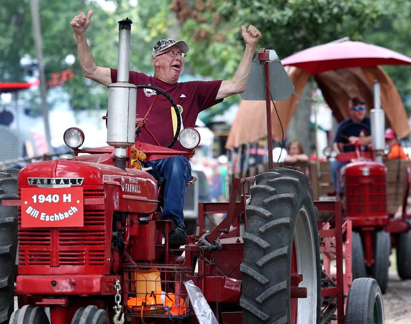 Bill Eschbach, from Marengo, gets excited while driving his 1040 Farmall H tractor through the parade Thursday, Aug. 7, 2025, at the 68th annual Sycamore Steam Show and Threshing Bee at Taylor Marshall Farm on Lukens Road in Sycamore.