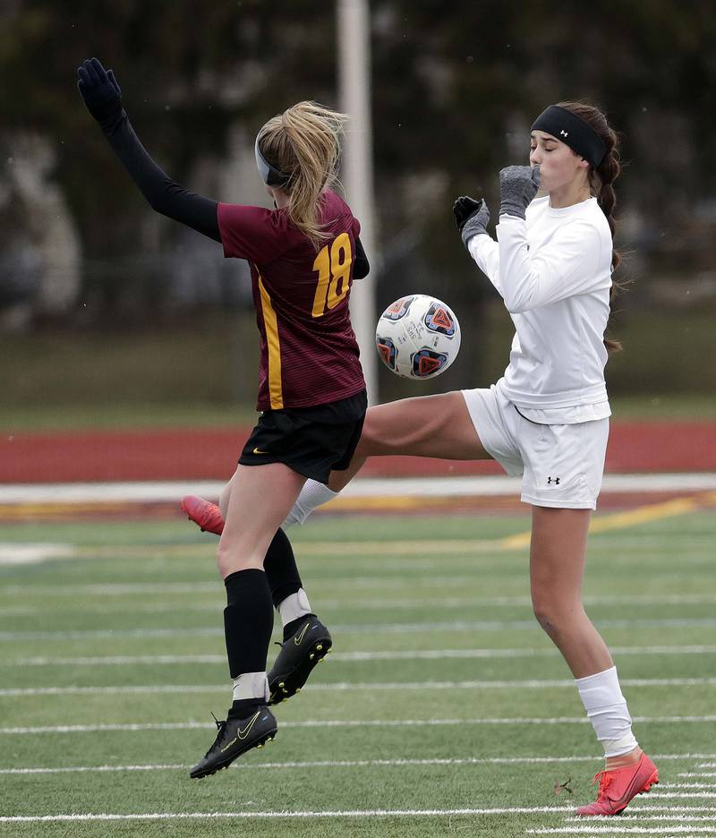 Crystal Lake South's Carly Gorman gets a knee on a long shot as Schaumburg's Caroline Chalberg defends during girls soccer action Saturday, March 26, 2022 in Schaumburg.