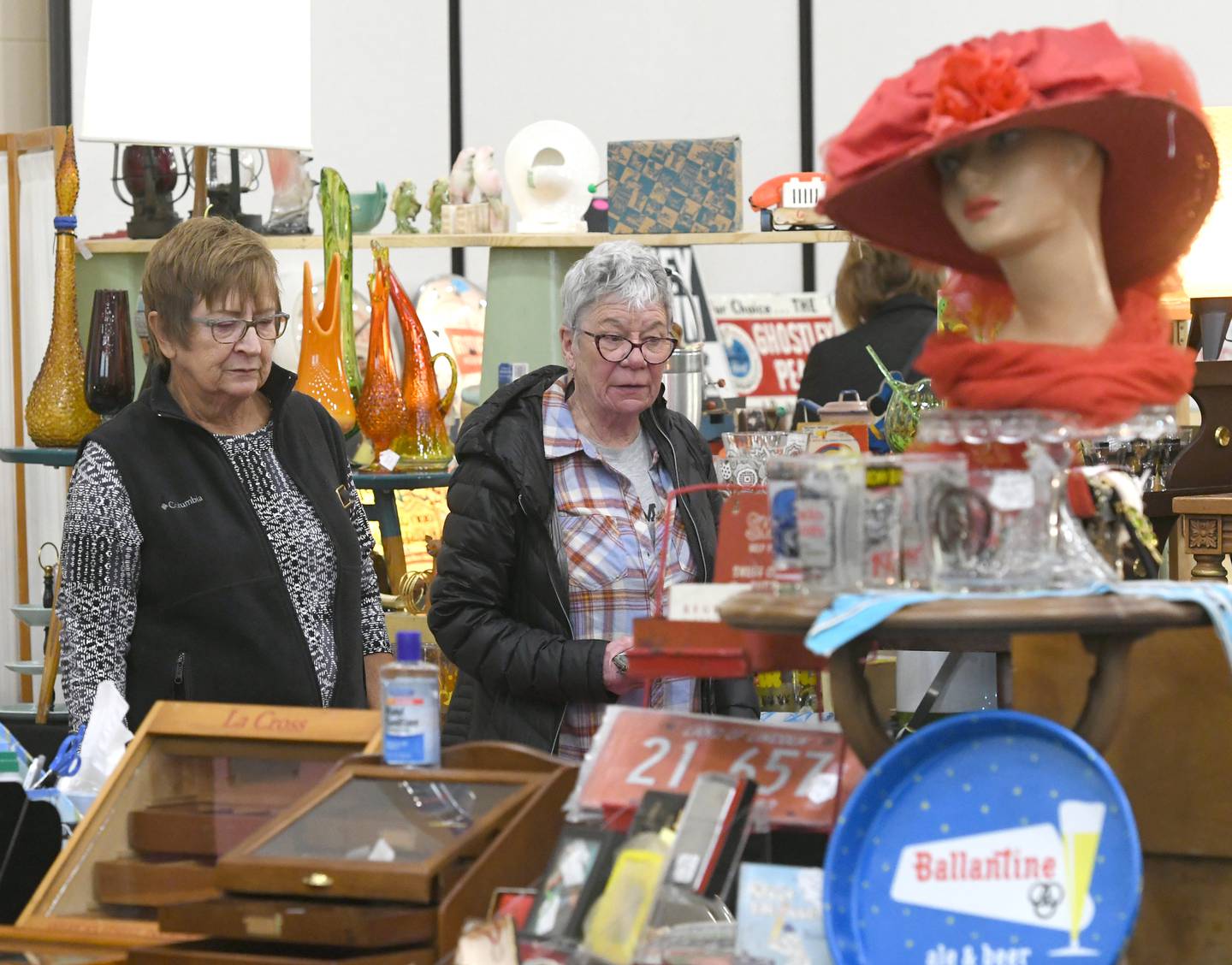 Linda Dunphy of Dixon (left) and Susie Lendman of Sterling look at antiques in Tammy Mendoza's booth at the Oregon Woman's Club Antique Show on Saturday in Oregon. Mendoza's antique shop 'The Cottage' is located in Coal Valley. She was one of 44 dealers at this year's event.