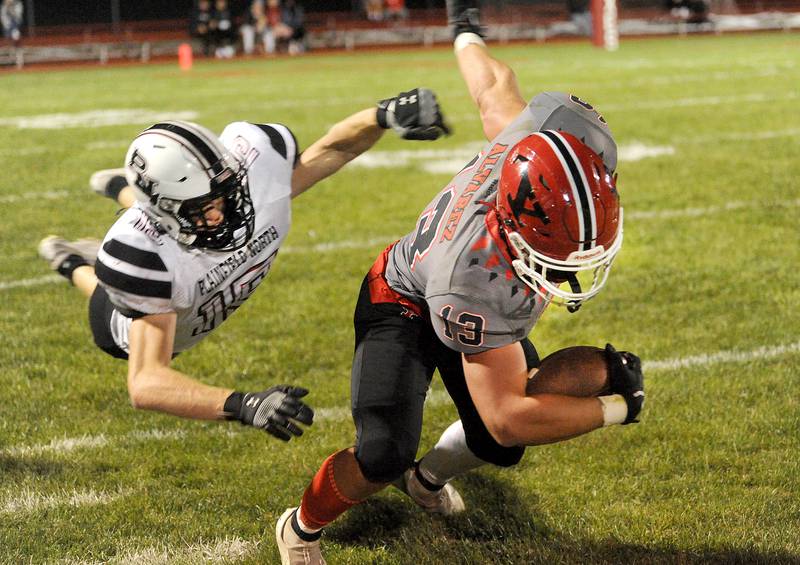 Yorkville running back Ben Alvarez (13) breaks the tackle of Plainfield North defender Ty Schaumleffel (19) and powers for a first down during the homecoming varsity football game at Yorkville High School on Friday, Sept. 23, 2022.