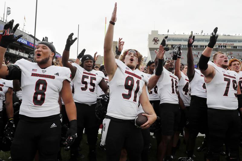 Northern Illinois long snapper Isaac Hatfield (91) and defensive tackle Devonte O'Malley (8) celebrate with teammates and fans after defeating Boston College in overtime, Saturday, Sept. 2, 2023, in Boston.