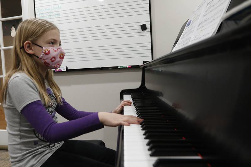 Claire Koll, 8, of Crystal Lake, plays the piano during a lesson Tuesday, Feb. 22, 2022, at Encore Music Academy, 87 N. Williams St., in Crystal Lake. The academy moved into its new location over Thanksgiving week last year. The larger location allows for the expansion of its private student instruction and also has a large space suitable for performing.
