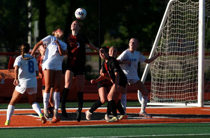 St. Charles East's Reese Kyle (center) heads the ball during the Class 3A St. Charles East Regional final against Geneva on Friday, May 23, 2025 in St. Charles.