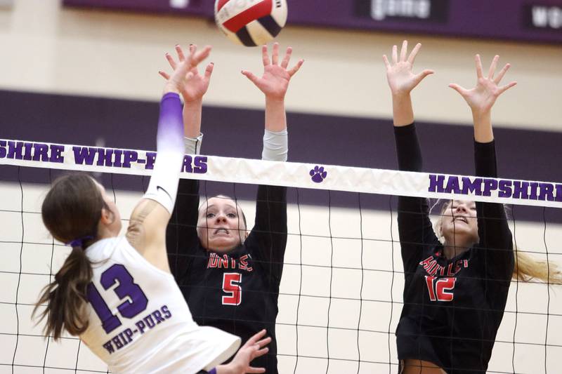 Huntley’s Emily Ernst, center, and Summer Massow, right, block against Hampshire’s Keira Skerke in varsity girls volleyball at Hampshire High School in Hampshire on Tuesday, Sept. 23, 2025.