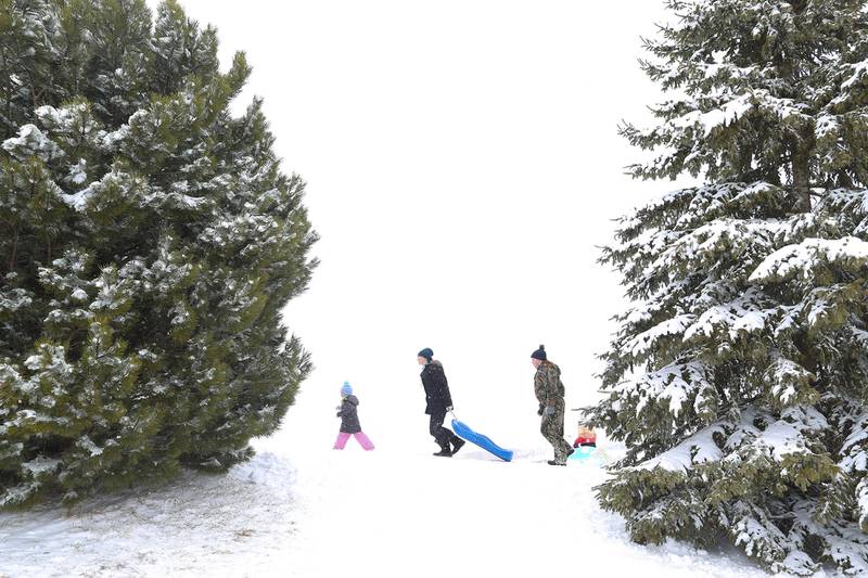 Sledders make their way up the hill on Sunday, Jan. 31, 2021, at Cene's Four Seasons Park in Shorewood, Ill. Nearly a foot of snow covered Will County overnight, resulting in fun for some and challenges for others.