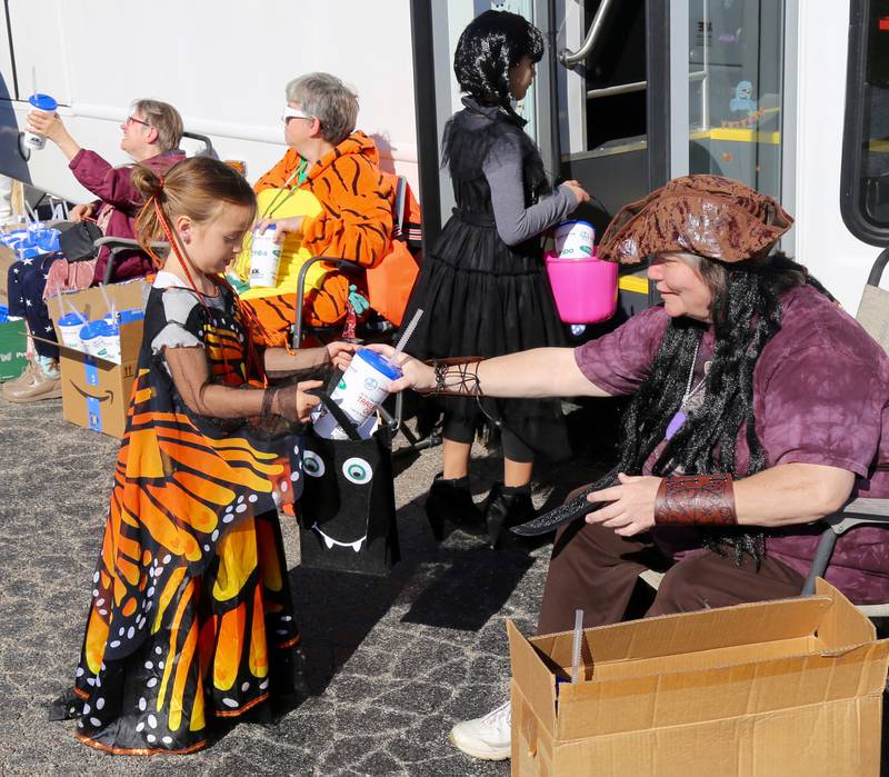 Roxy Fletcher gets a water bottle from the Open Door at the Fox Valley Family YMCA West branch Trick or Trunk on Sunday, Oct. 26, 2025 in Sandwich.