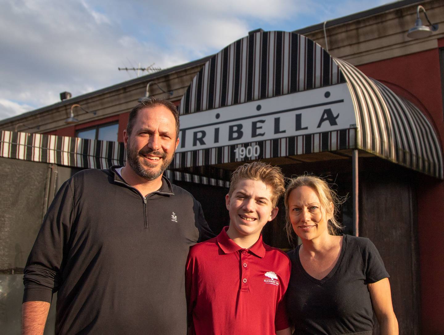 Co-Owner s Joe, left, and Christine,right, DiGuglielmo pose with their son Joe DiGuglielmo in front of Tribella Bar and Grill in Batavia on Sunday, March 26, 2023, the last day their restaurant was open.