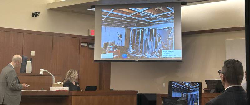 Assistant Ogle County State's Attorney Matthew Leisten (far left) showed photographs to jurors that were taken by crime scene investigators at Maggie Meyer's home after she was discovered dead inside the first floor of her burned home. This photo shows the damage to the home's basement following the fire. Her ex-husband, Duane C. Meyer (far right) is on trial for killing her and setting the home on fire.