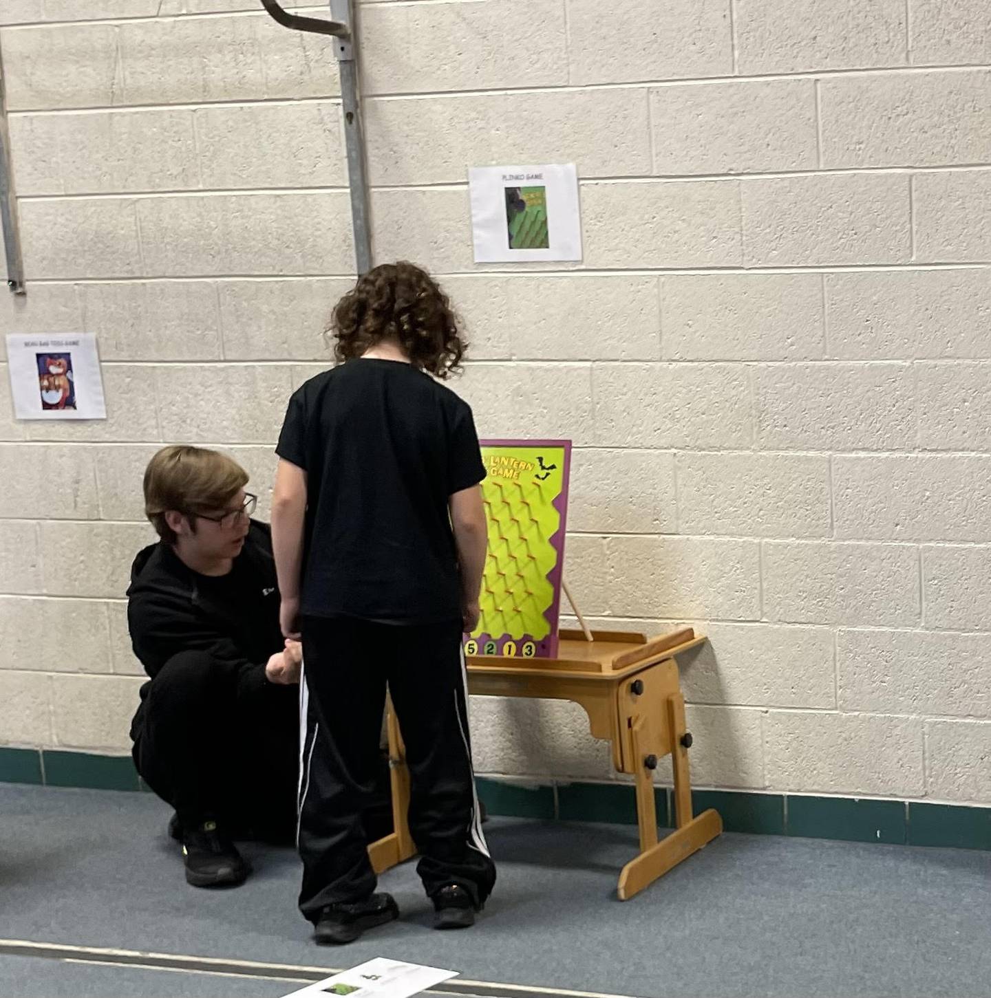 BEST high school students oversaw fall themed carnival games Oct. 24, 2024, for the younger students. The BMP Tri-County Special Education Cooperative helped make this day possible. Ameliah Sedam learns how to play a Plinko type game from Joseph Horner.