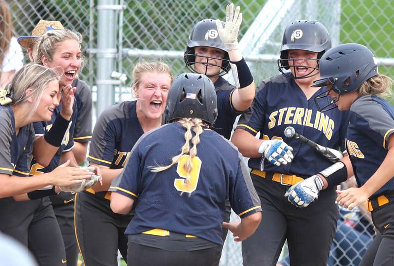 Sterling players wait at home plate for Ellie Leigh after she homered Tuesday, May 31, 2022, during their Class 3A Sectional semifinal game against Kaneland at Sycamore High School.