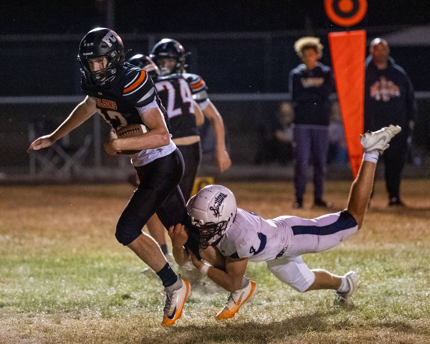 Logan Ruddy (12) of FCW runs ball as Rob Sandberg (4) of Ridgewood holds onto right leg earlier this season at Woodland School in rural Streator.