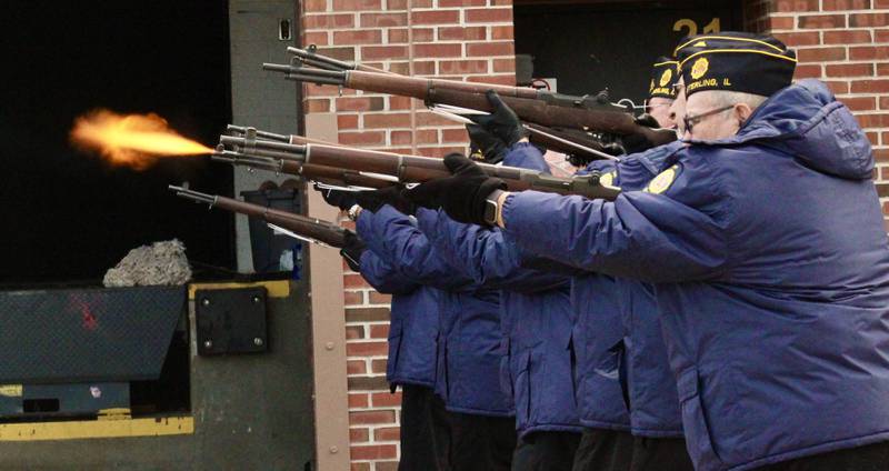 Sterling American Legion Post 296 honor guard fires a volley as part of a salute on Friday, Nov. 11, 2022, in the street outside Centennial Auditorium at Sterling High School. The sound of the gunfire can be heard by those in the auditorium through the loading dock that is behind the main stage.